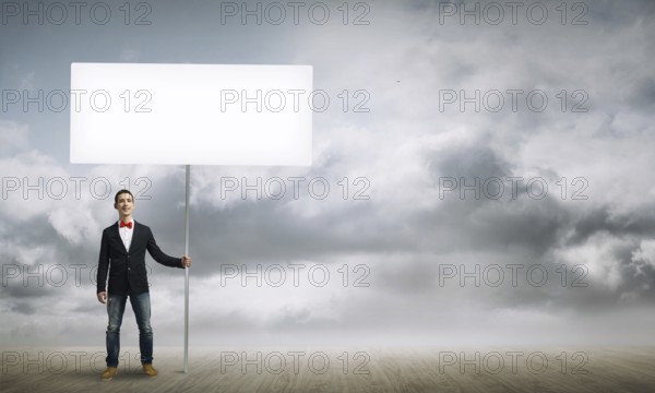 Fullbody of handsome guy holding white blank banner