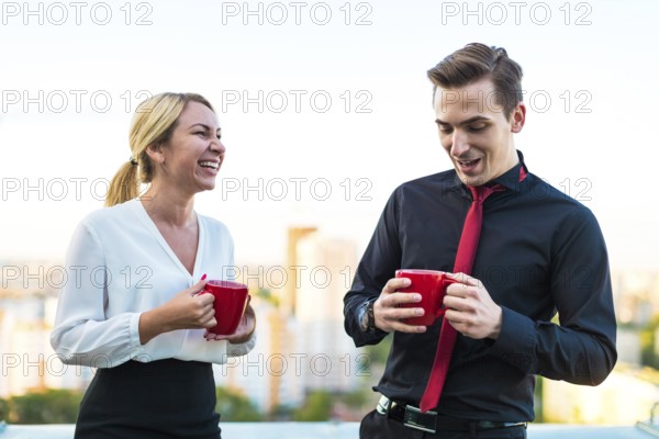 Couple of caucasian businessmen, young attractive brunette man in dark suit, red tie and black