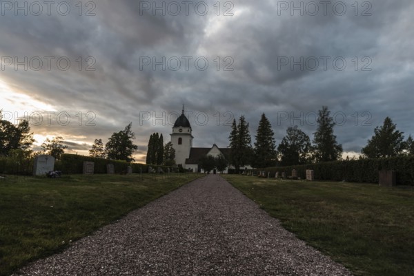 Rattvik, Dalarna, Sweden, 08 05 2019: View over the cloudes graveyard and the small church at dusk,