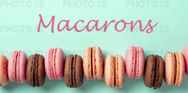 Macarons concept. Letters macarons on turquose bright bacground and row of french macarons