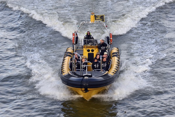 Speedboat with several people travelling at high speed across the water, London, London region,