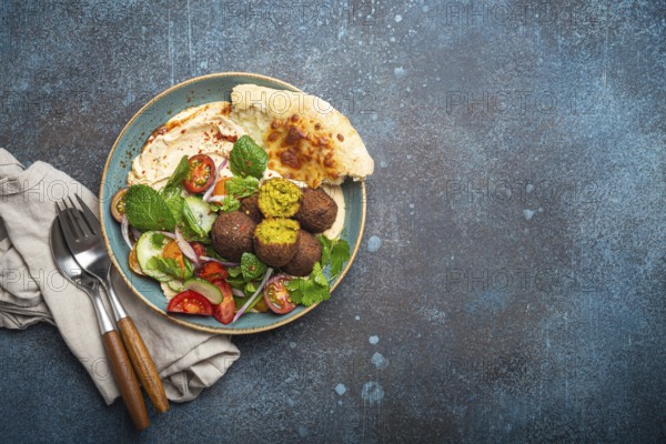 Middle Eastern Arab meal with fried falafel, hummus, vegetables salad with fresh green cilantro and