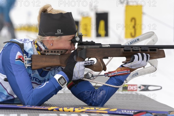 Biathlete Kseniya Petrunova rifle shooting in prone position. Biathlete in shooting range Junior
