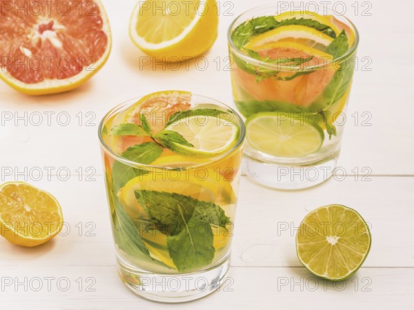 Cold homemade lemonade with fresh lemon, lime, grapefruit and mint. Summer drink on white wooden