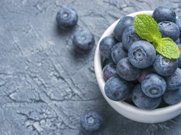 Freshly picked blueberries closeup. Ripe and juicy fresh blueberry with green mint leaves on