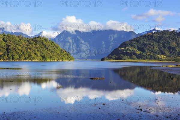 Stony shallows. A wonderful day on the river. Snow-capped mountains reflected in the smooth water.
