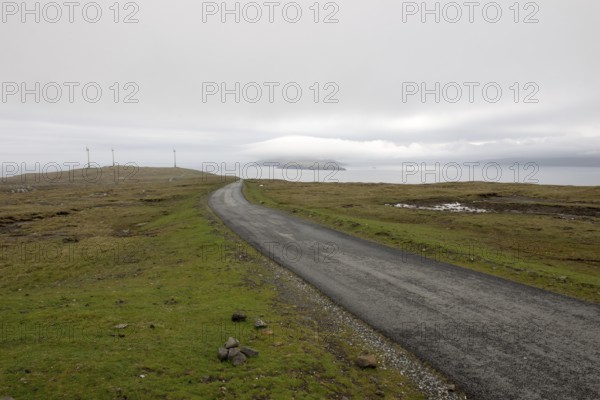 Street on the Faroe Islands in the south of Eysturoy with wind mills and nolsoy, Æduvik, Faroe
