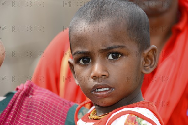 Coastal temple of Mahabalipuram, Mamallapuram, A child in red clothes with a curious and serious