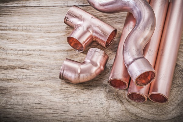 Copper water pipe coupling tools on wooden board plumbing brassware concept