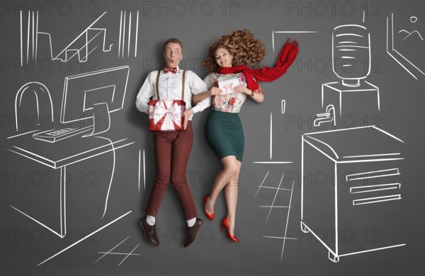 Happy valentines love story concept of an office romance. Young couple at work smiling at each