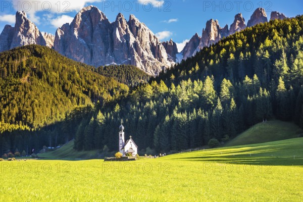 Dolomites, Tirol. Sunny autumn day. The famous symbol of the valley Val di Funes - church of Santa