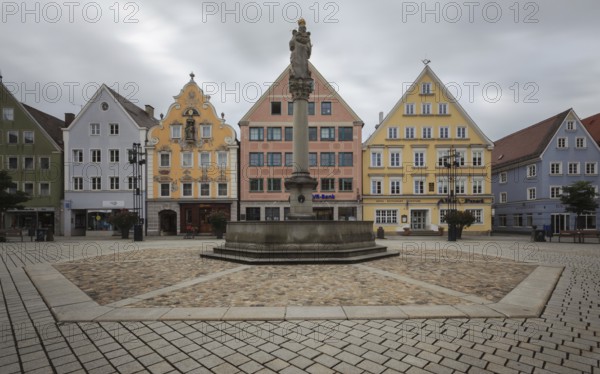 An empty market square with a statue surrounded by pastel-coloured historic buildings, Old Town