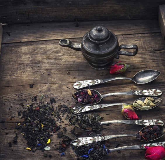 Varieties of dry tea infuser scattered on wooden table