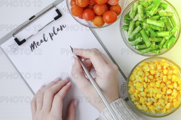 Meal plan. Three Bowls of frozen vegetables food of yellow corn, green beans, red tomatoes. Colors