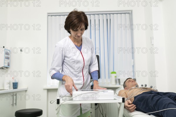Medical equipment for electrocardiogram. Doctors doing ECG test on male patient. Diagnostic heart