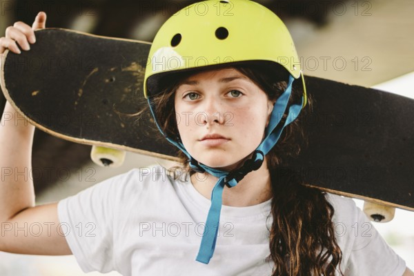 Schoolgirl after lessons at skateboarding practice in outdoor skate park. Stylish and beautiful