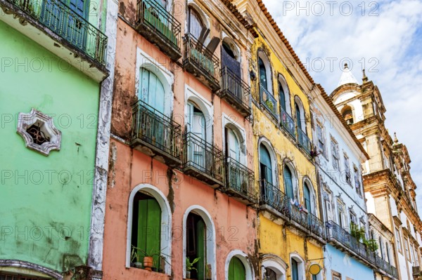 Facades of colorful houses and church in baroque and colonial style damaged by time in the
