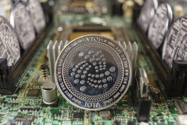 IOTA coin close-up on a computer circuit motherboard as a blockchain technology payment network.