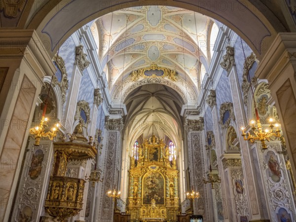 Magnificent interior of a baroque-style church with richly decorated altar and ceiling paintings