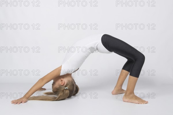 Six year old girl aspiring gymnast performs a number of training exercises