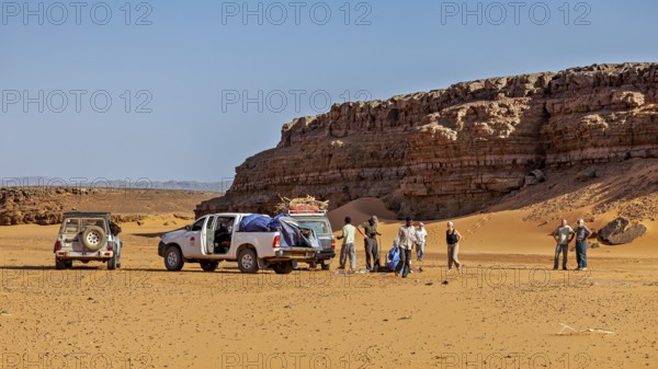 Off-road vehicle and people in a sunny desert landscape with impressive rock formations, Off-road