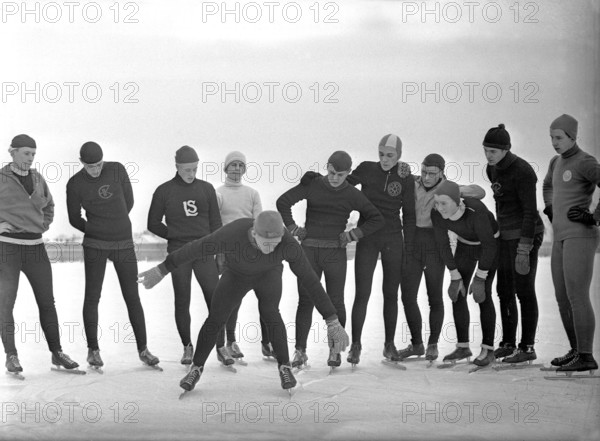 1930s winter activities. A group of amateur long distance scaters has gathered around a man who