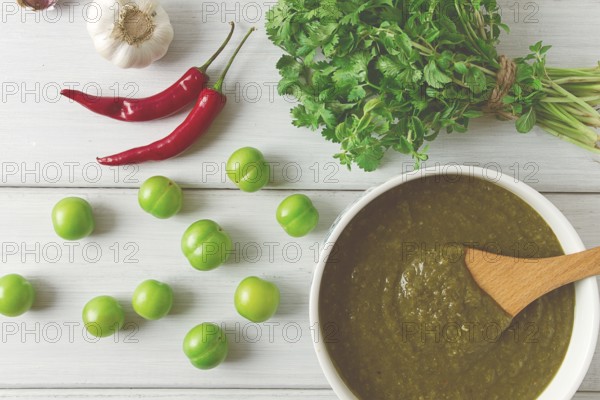 Tkemali sauce, traditional Georgian cuisine, green cherry plum, with ingredients for sauce,
