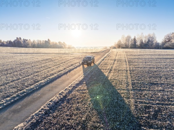 An SUV drives along a frosty country road in the winter morning light, Car Sharing, Electric car,