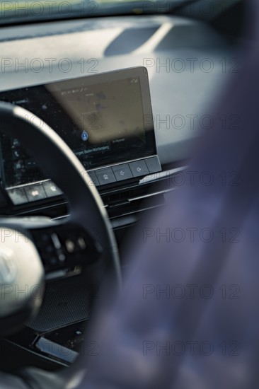 Detailed view of a modern car interior with steering wheel and display on the dashboard, e-car