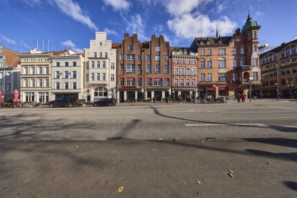 Row of historic buildings, brick buildings, gables, blue sky with cumulus clouds, street An der