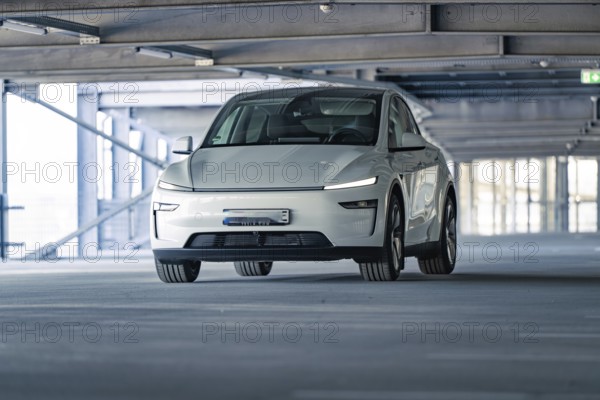 Electric car with modern shapes in a dimly lit car park, Tesla New Model Y Juniper, Calw, Germany,