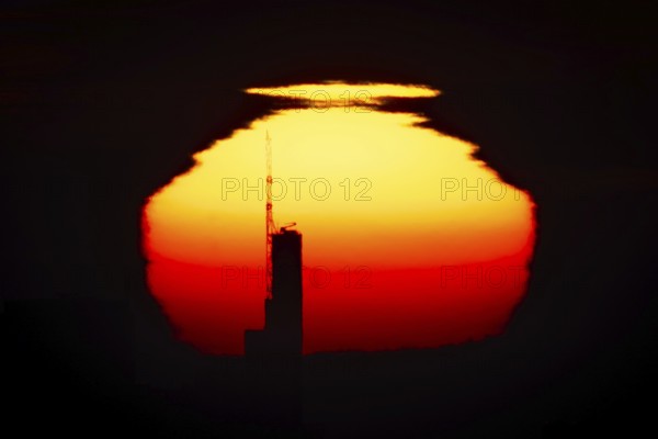 The top of the Commerzbank Tower in Frankfurt am Main stands out against the rising sun, Frankfurt