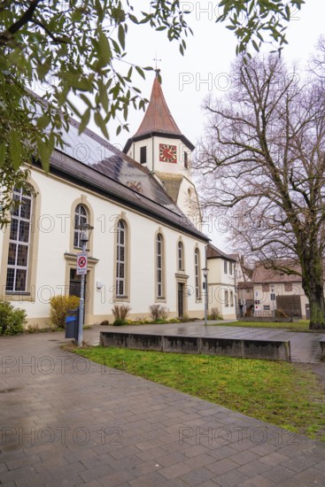 Old church surrounded by trees, well-kept pavement in the foreground, quiet atmosphere,
