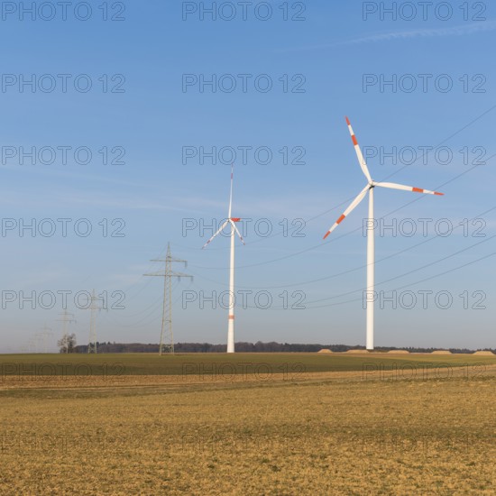 Wind turbines and power lines in an autumnal field under a clear sky, solar park, near Ulm, Swabian