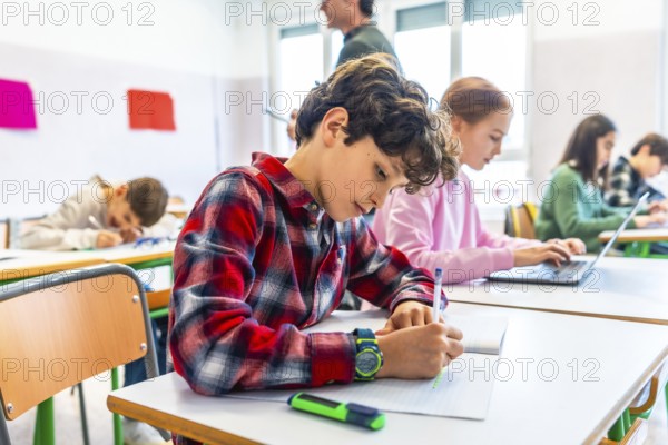 Elementary school students are diligently working at their desks, some writing in notebooks and