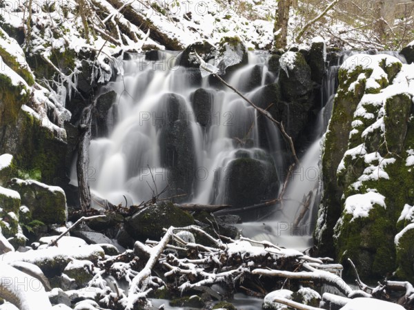 Teufelsmühle waterfall on the hill stream the Schwartzbach, in snow and ice in November. The Rhön
