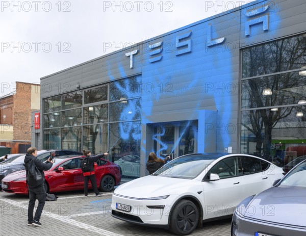 Emma Dorrow and Judith Beadle from the New Generation spray TESLA store with AfD blue paint. Tesla