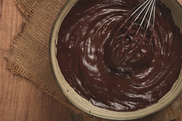 A bowl of chocolate dough, a whisk for whipping, baking, structure and consistency, homemade, top