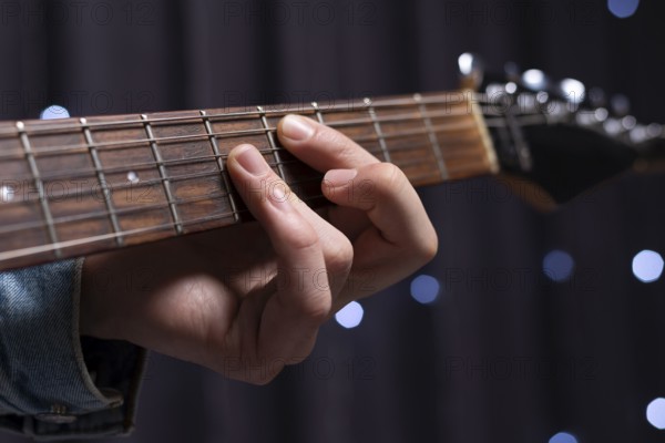 Image of the hands of a musician playing the electric guitar. The concept of concerts and