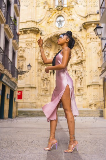 Beautiful Dominican ethnic girl with braids with a beautiful pink dress. Fashion enjoying summer in
