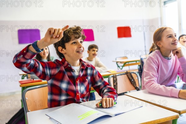Elementary school student raising hand to answer a question during class, showing eagerness to