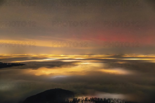 Firework lights under the sea of fog. New Year's Eve fireworks 2024 and a little red Aurora