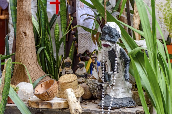 Afro-Brazilian religious altar with Umbanda objects and entities among plants, Belo Horizonte,