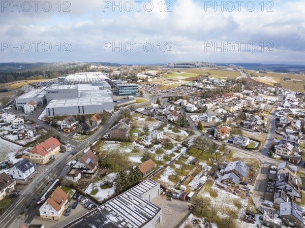 Bird's eye view of industrial area and neighbouring residential buildings in winter landscape,