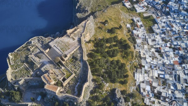 Drone shot, Acropolis of Lindos, late afternoon light, aerial view of an ancient fortress on the