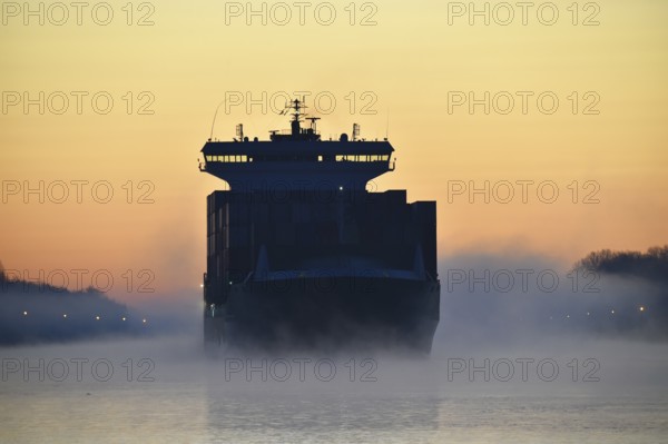 Container ship sailing at sunrise and fog in the Kiel Canal, NOK, Kielkanal, Kiel Canal,