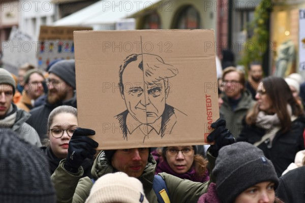 Heidelberg, Germany - February 12th 2025: Person holding up sign comparing CDU politian Friedrich