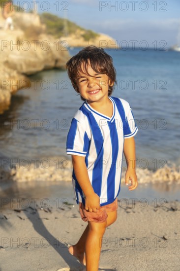 Happy child walking on the beach of s'amarador in mallorca, spain, enjoying summer holidays by the