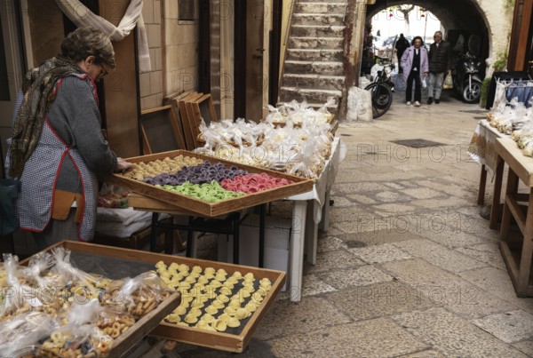 Bari, Italy, 27 November, 2023: woman pasta maker laying out her wares in the iconic Strada del
