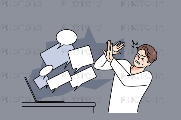 Stressed man overwhelmed with online negative comments and messages on computer. Unhappy guy